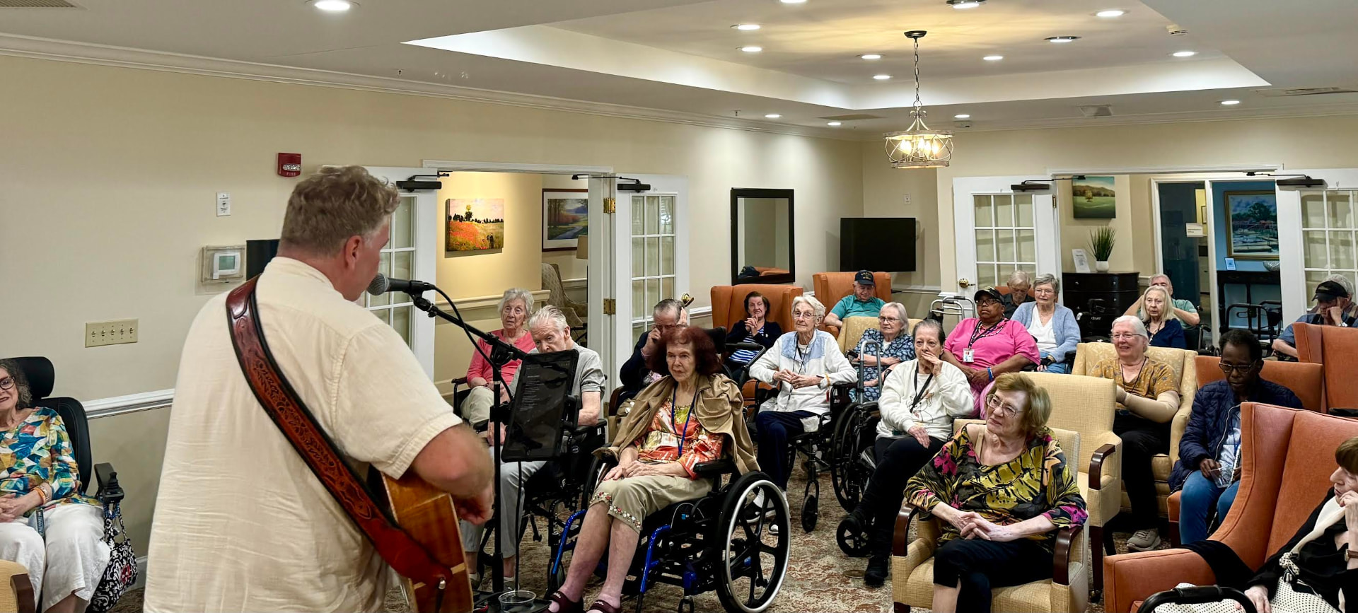 Ehlert performing with guitar for a room of residents