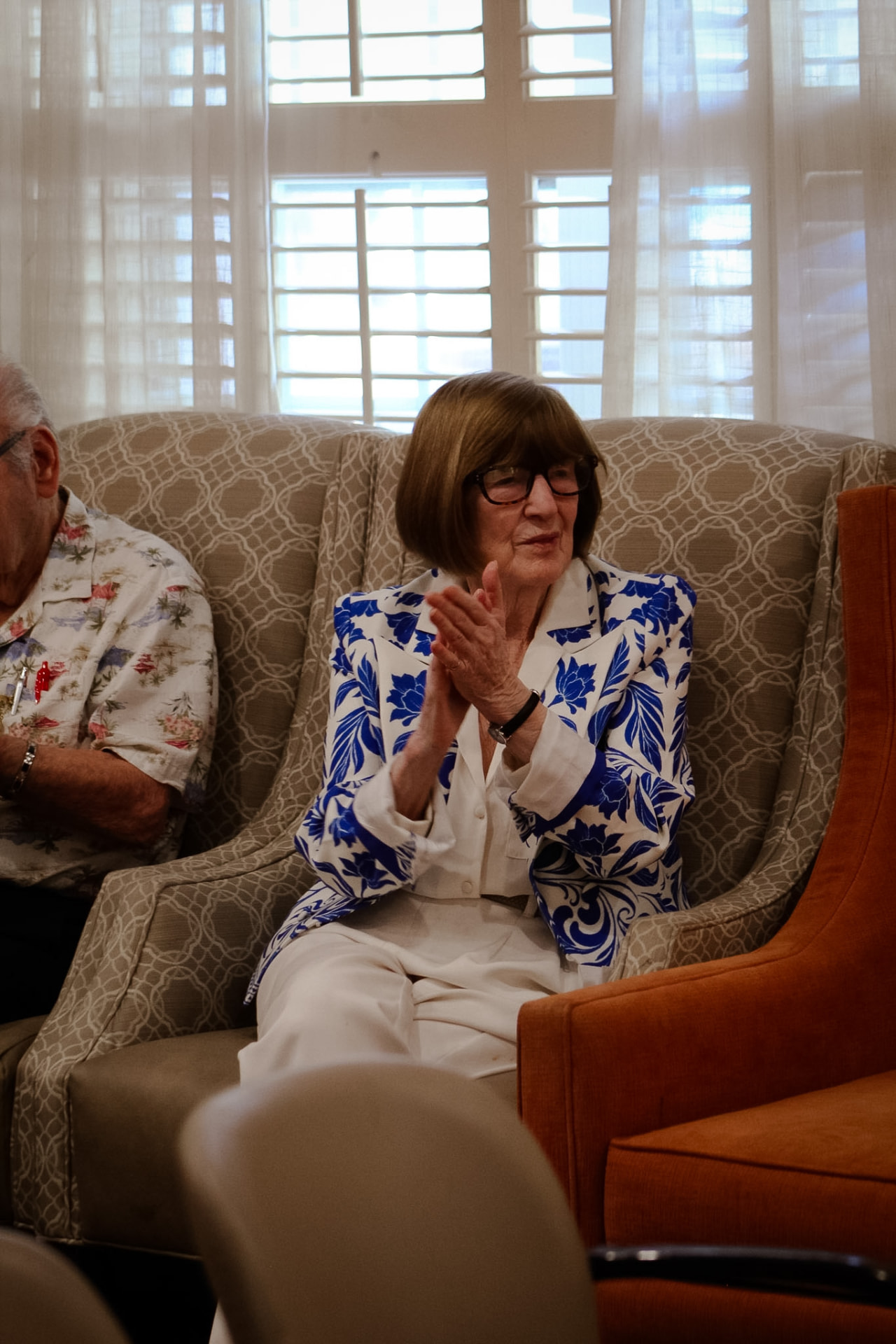 A resident clapping along from her armchair