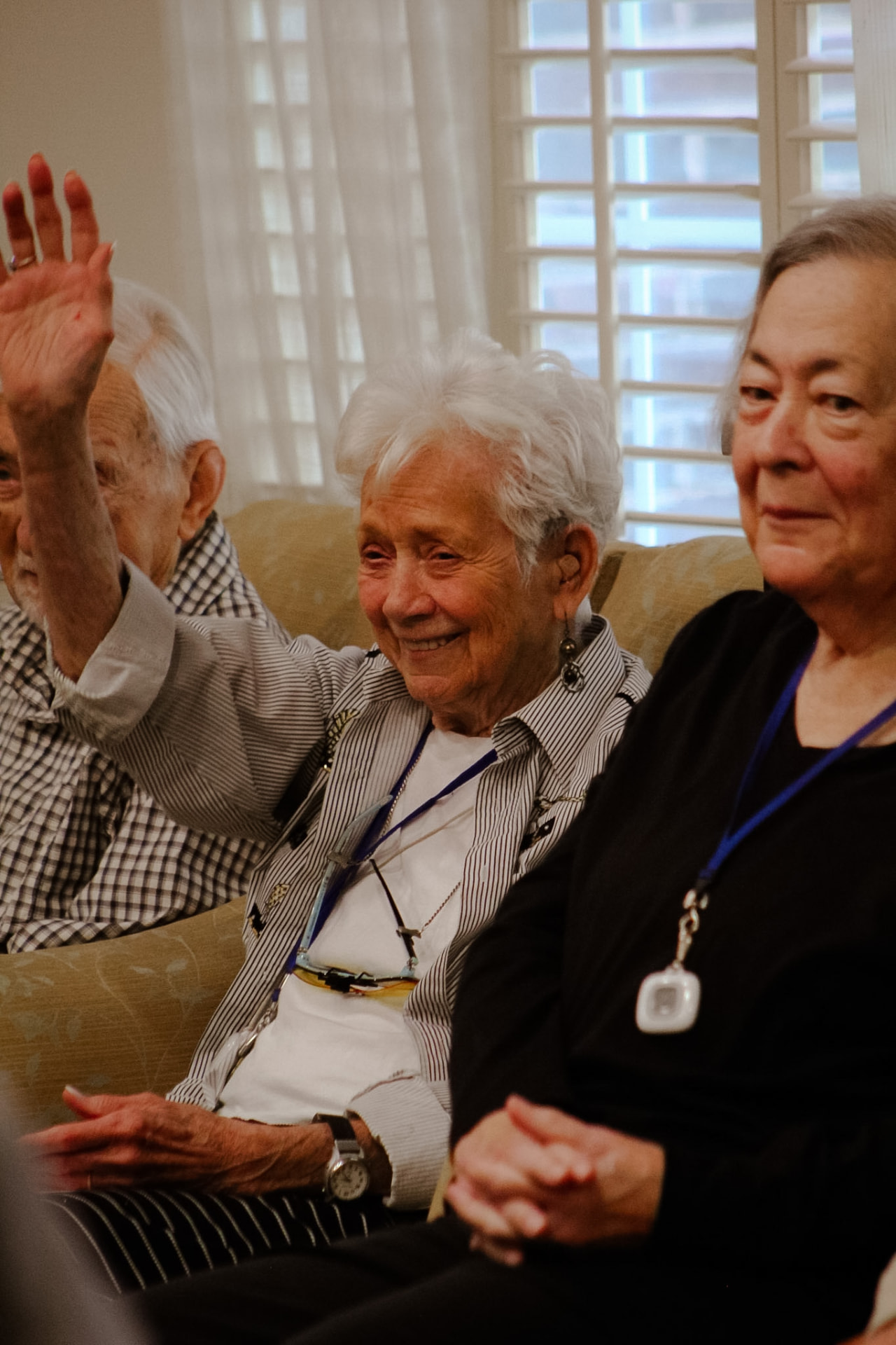 Residents raising their hands and smiling during a sing-along