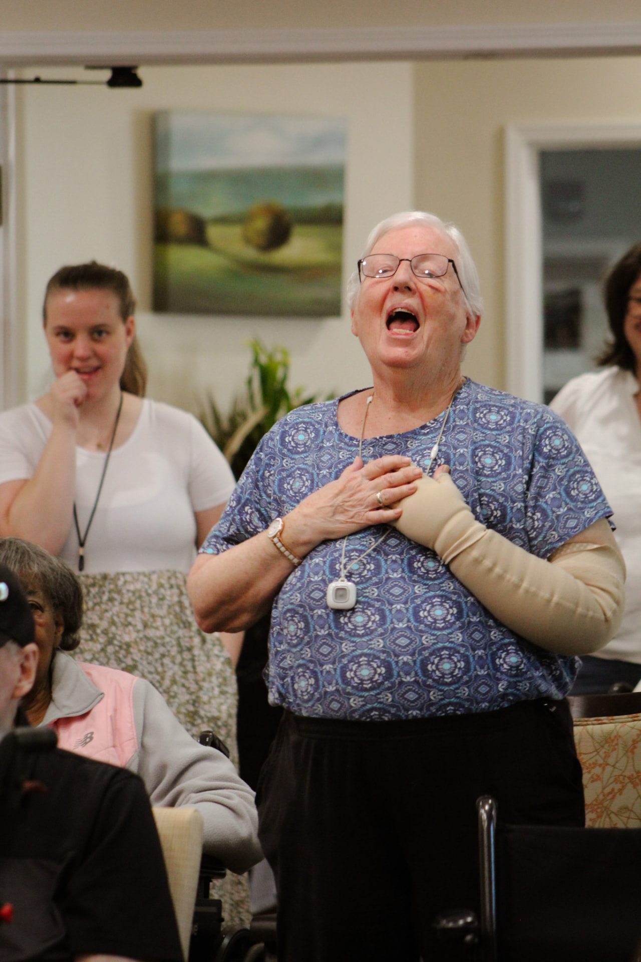 A resident singing along with her hands over her heart